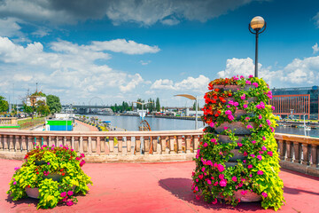 Flower decoration on Long Bridge, called Most Dlugi and view on Wieleckie Quay in Szczecin, Poland. Promenade and boulevards on Odra River embarkment - obrazy, fototapety, plakaty