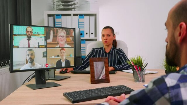Paralysed freelancer in wheelchair having videomeeting discussing online with remotely colleagues in business office. Handicapped businessman working in financial company using modern technology.