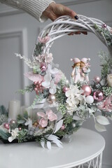 Cristmass decoration  with dolls and pine on hands  and house on table