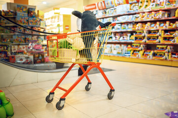 Cart with soft toys in children's store, nobody