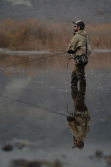 Naklejka premium portrait of fisherman in the lake at sunset