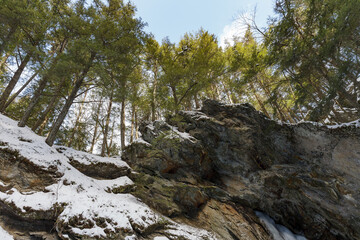 Moss Glen Falls in winter after snow storm. Water turned into ice and is covered with a snow. Bright sunny day.