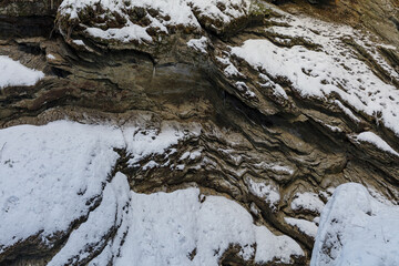 Moss Glen Falls in winter after snow storm. Water turned into ice and is covered with a snow. Bright sunny day.