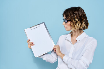 Business woman with documents in a folder on a blue background and in a light shirt glasses on her face