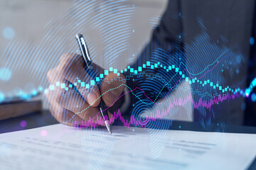 Businessman in suit signs contract. Double exposure with forex graph hologram. Man signing brokerage agreement. Financial market analysis and investment concept.