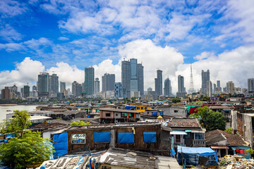 Views of slums on the shores of mumbai, India against the backdrop of skyscrapers under construction