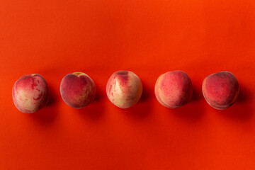 Fresh, ripe peaches on an orange background. Delicious and healthy fruits.