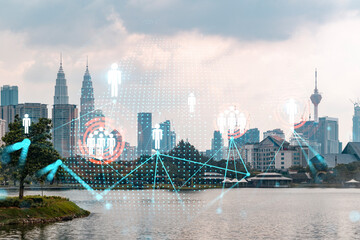 Obraz premium Hologram of social media icons over sunset panoramic cityscape of Kuala Lumpur, Malaysia, Asia. The concept of people connections in KL. Multi exposure.