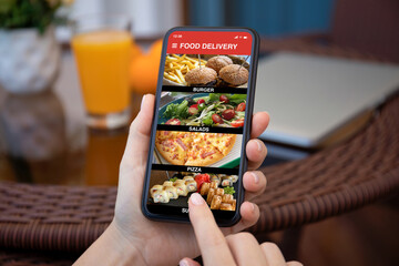 female hands hold phone with food delivery application on screen