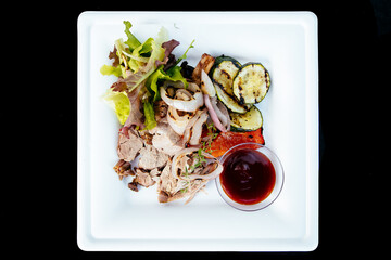 Green meat salad and vegetable with tomato sauce on a white plate