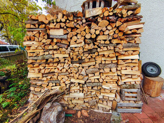 a stack of firewood in front of a house