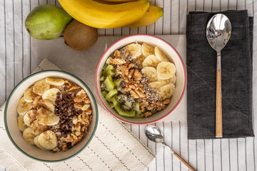 Top view of a porridge bowl with banana, kiwi, and a pear.