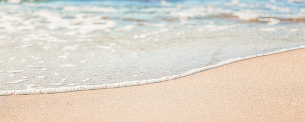 the waves of the sea on the sandy beach on a sunny day