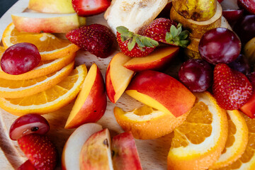 Fruit cutting on a plate. Apelsygs, grapes, apples and strawberries.
