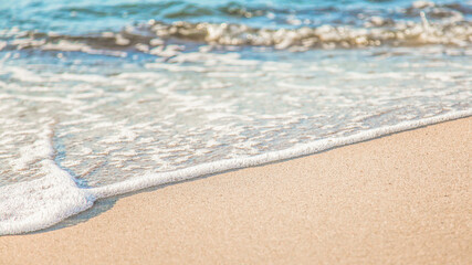 the waves of the sea on the sandy beach on a sunny day