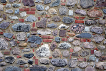 Natursteinmauer aus unregelmäßig großen und unbehauenen Steinen gemischt mit Ziegeln 
