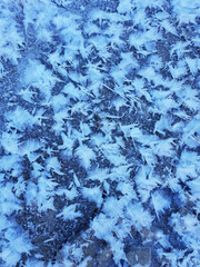 Snowflakes as a snow butterflies over frozen icy river. Frosty nature background.