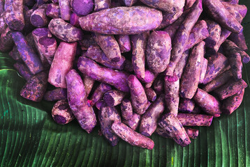 raw purple sweet potato on green banana leaf