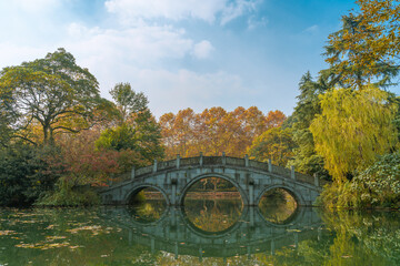 A Chinese stone bridge at the lakeside of West lake in Hangzhou, China, autumn time.