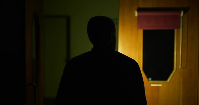 Man exploring derelict building alone using phone flash light at night