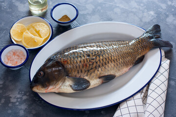 Raw carp with baking ingredients - lemon, salt, spices, horizontal