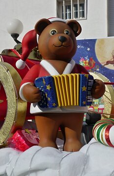 Funny colorful bear with accordion on a christmas market 