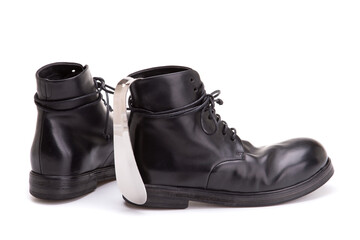 Metal Shoe spoon. Shoe spoon and large black leather boots. Pair of men's shoes and a silver spoon...