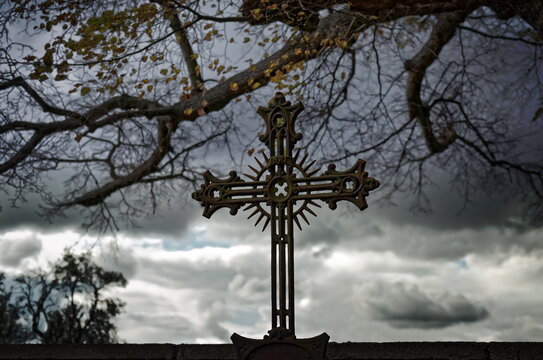Old iron croos of a grave in autumn
