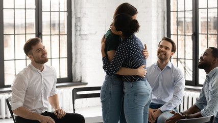 Support and assistance. Indian female psychologist providing therapy working with diverse group of young people with drug alcohol addiction embracing young woman helping overcome problem giving hope