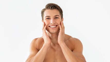 Portrait of man touching his face at white studio