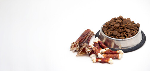 Dog treats and dry feed in bowl on white background with copy space. Variety of dog treats. flat lay