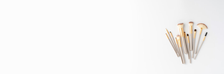 Beautiful makeup brushes isolated on white background with copyspace. Top view. Banner