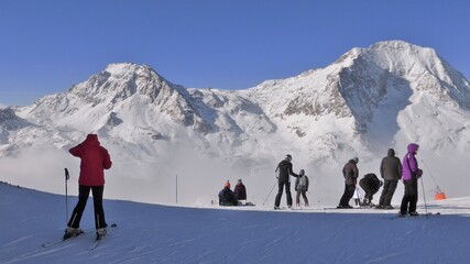 Skieurs au sommet d'une montagne couverte de neige dans les Alpes, pr&ecirc;ts &agrave; s'&eacute;lancer sur une piste de ski, &agrave; Aussois dans la Haute-Maurienne en Savoie (France)