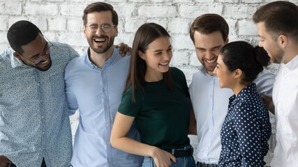 Sincere laughter. Overjoyed millennial multiethnic friends gathered together on informal meeting,...