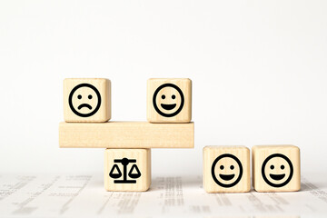 Close up custome choose face and blurred sad face icon on wood cube, Service rating, satisfaction concept.