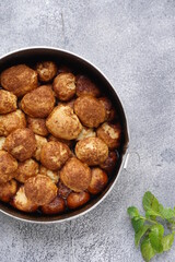 Grainy texture of Monkey bread or Cinnamon pull apart bread in a circle cake mold. Isolated grainy texture gray background with a Mint leaf
