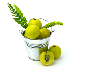 Amla with leaves in a bucket isolated on white background