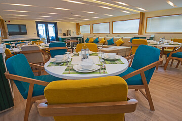 Interior of large salon dining area of luxury motor yacht