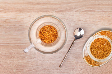 Granules of instant coffee in glass cup. Top view.