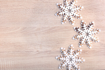 Christmas New Year background with wooden snowflakes. Top view with copy space.