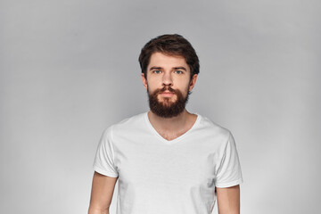 Fototapeta premium cheerful emotional bearded man gesturing with his hands close-up light background