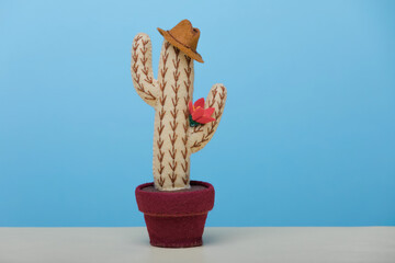Potted felt toy Cowboy cactus with hat is on blue background. Concept father's day.