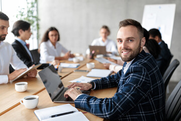 Happy Businessman With Laptop At Corporate Meeting In Office