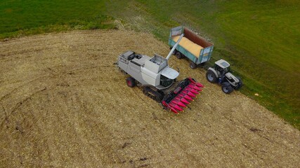 Maishäcksler und Traktor mit Anhänger bei der Ernte von Mais auf einem Acker, Landwirtschaft 