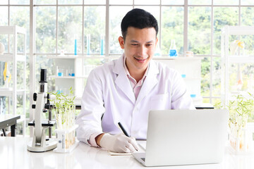 Scientists, researchers in Asia, use a laptop and record the results of the study. Or making a...