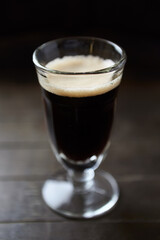 Glass of dark beer on dark wooden background. close up. 