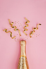 Gold glittering bottle of champagne and swirls on pink background