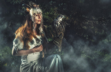 beautiful shamanic woman with eagle in the nature.