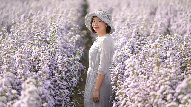 Asian woman photographed in a purple flower field.