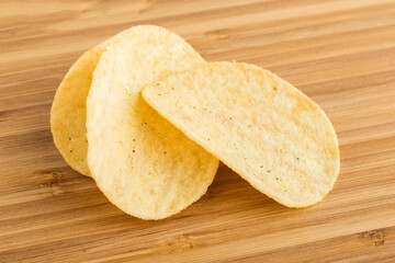 Potato chips on a wooden table. Salty beer snack. Close-up